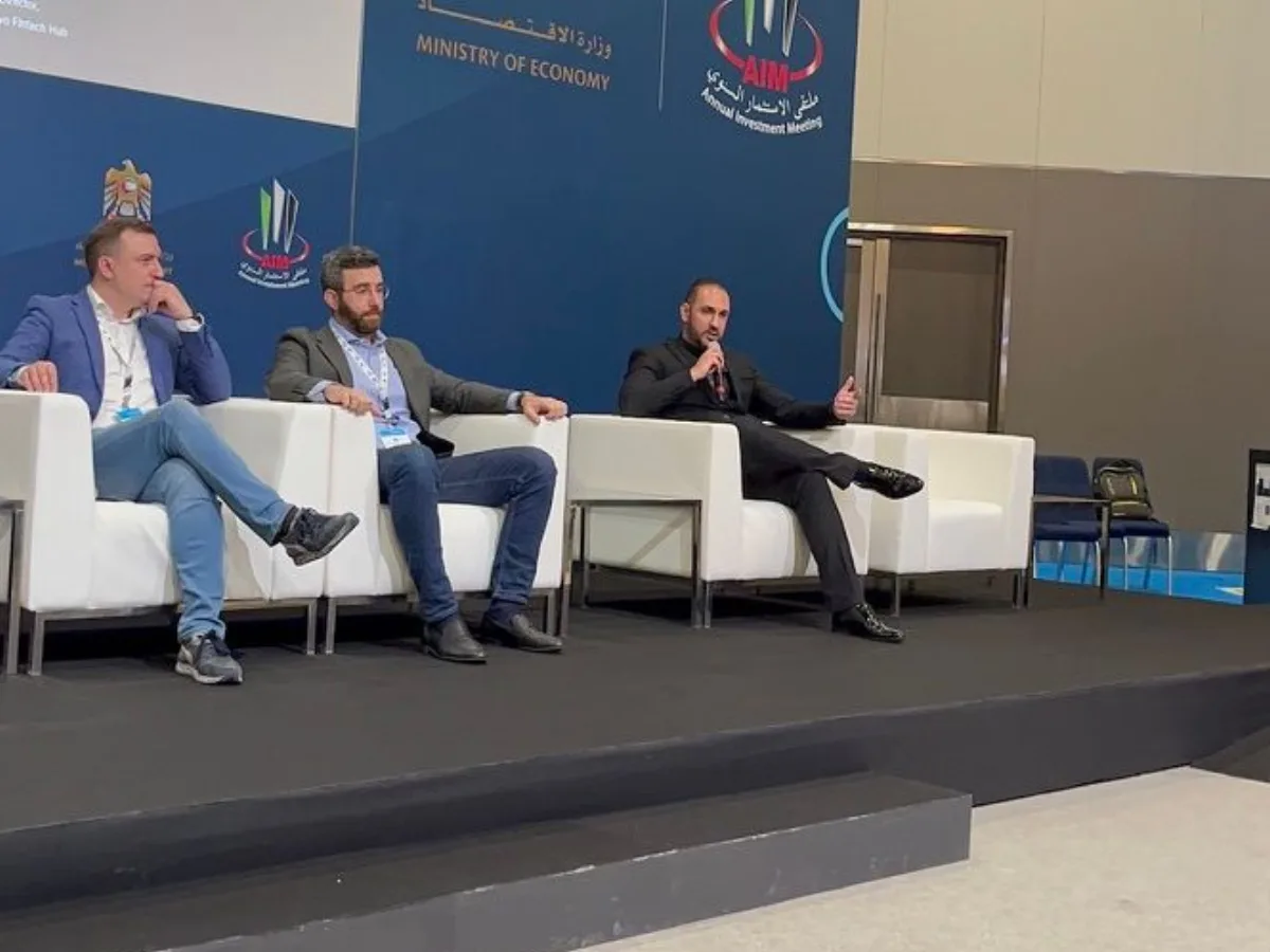 Arash Rezaei seated on a panel with other speakers at an investment meeting.