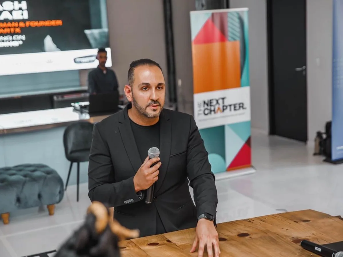 Arash Rezaei speaking with a microphone at a business event.