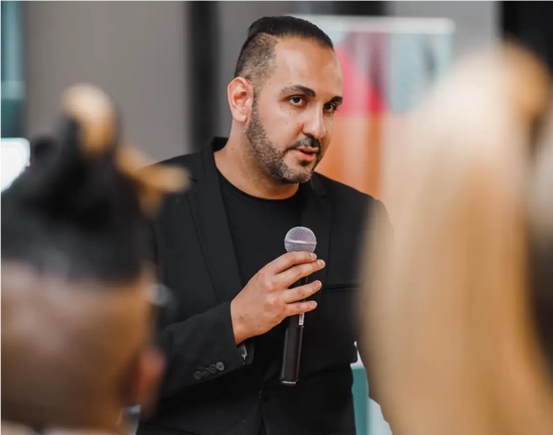 Arash Rezaei speaking on stage